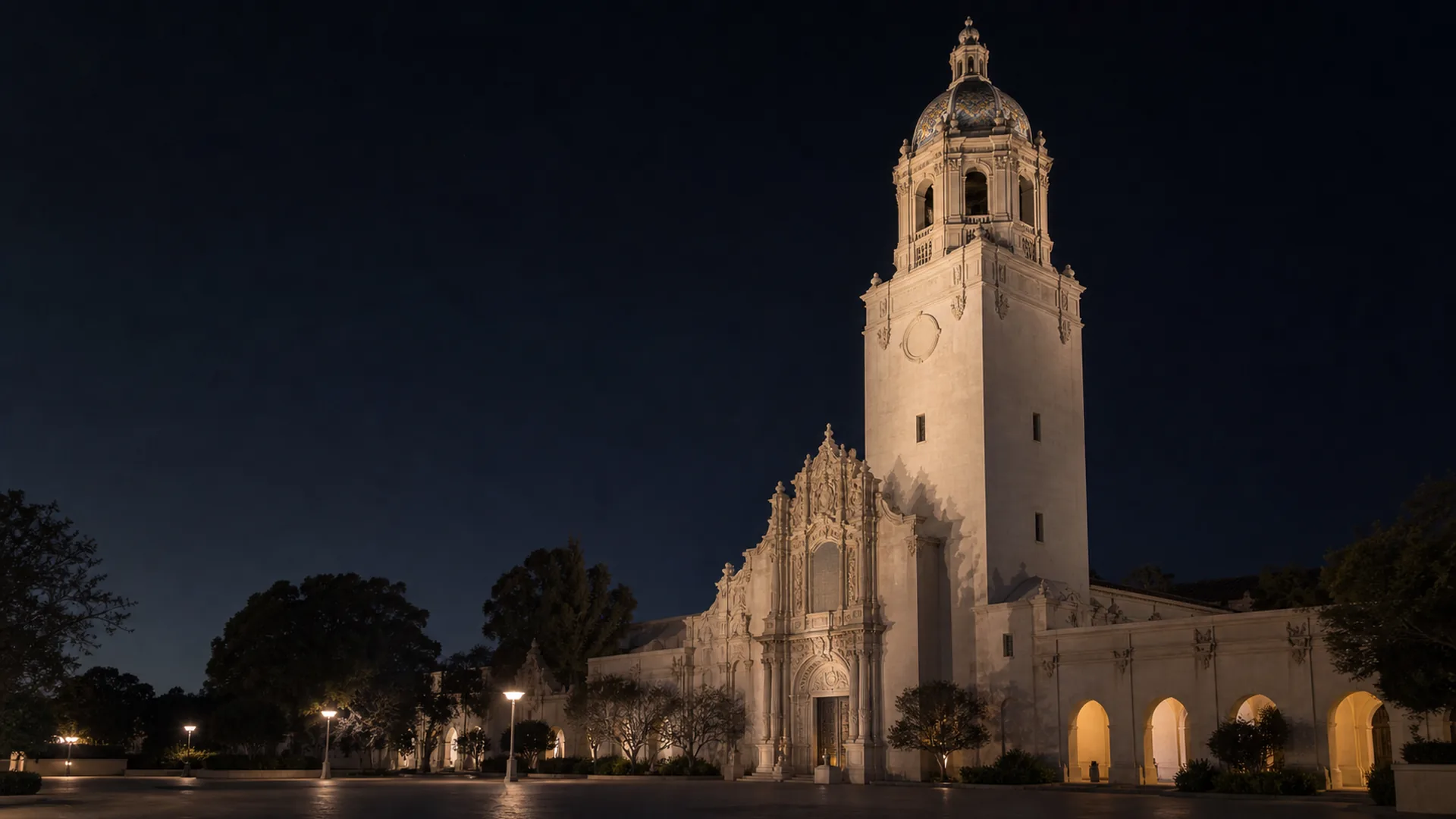 The California Tower rises above the ornate Museum of Us buildings in Balboa Park at blue hour.